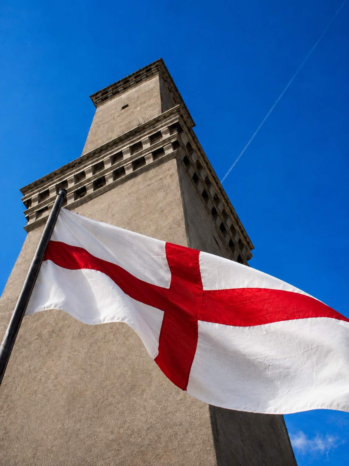 The St George’s Cross flag flying in front of Genoa’s Lanterna lighthouse